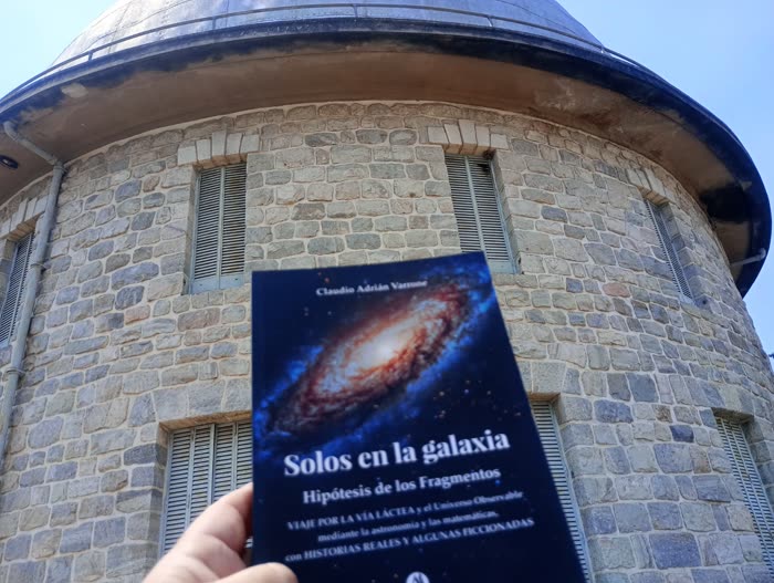 El libro Solos en la galaxia frente a un observatorio astronómico